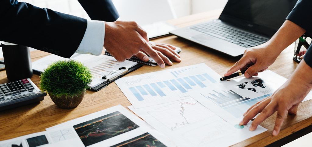 Group of Businesspeople discussing the charts and graphs,businessmen discussing on stockmarket document in office,Business partners consult documents at meeting,Concept of brainstorm teamwork planning